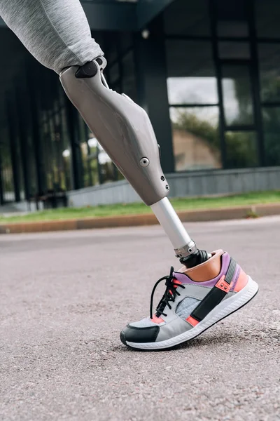 Partial view of disabled sportswoman with prosthesis on street — Stock Photo