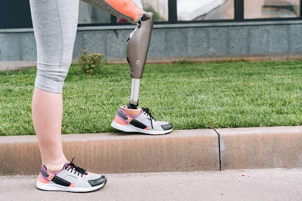 Partial view of disabled sportswoman with prosthesis on street — Stock Photo