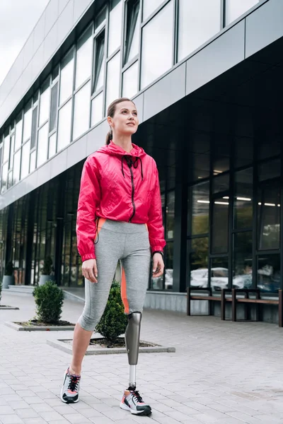 Full length view of smiling disabled sportswoman on street — Stock Photo