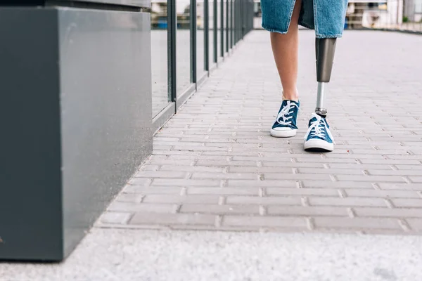 Cropped view of disabled woman with prosthetic leg on street — Stock Photo