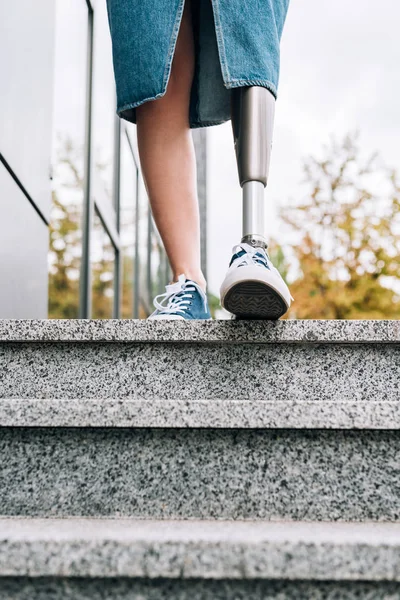 Cropped view of disabled woman with prosthetic leg on street — Stock Photo