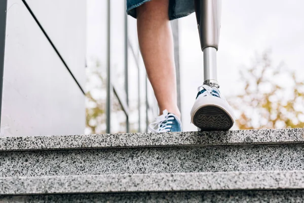 Cropped view of disabled woman with prosthetic leg on street — Stock Photo