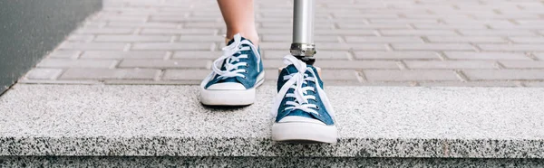 Panoramic shot of disabled woman with prosthetic leg on street — Stock Photo