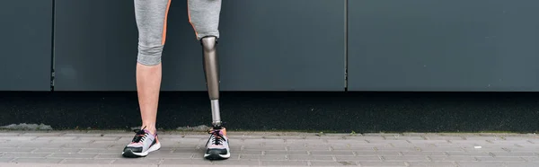 Panoramic shot of disabled sportswoman with prosthetic leg on street — Stock Photo