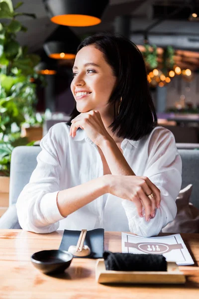 Enfoque selectivo de la mujer alegre sentado en el restaurante - foto de stock