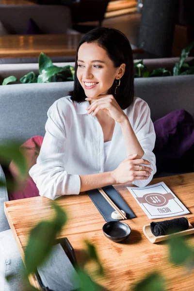 Selektiver Fokus einer glücklichen Frau, die im Restaurant sitzt — Stockfoto