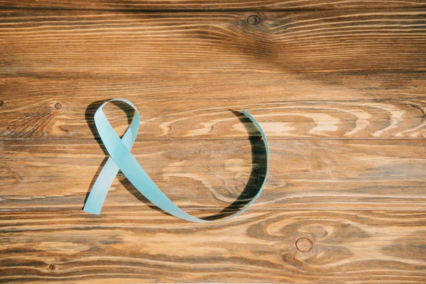 Blue awareness ribbon on wooden background with copy space — Stock Photo