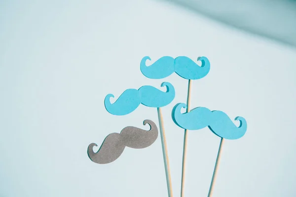 Blue and grey paper cut mustache on white background with copy space — Stock Photo