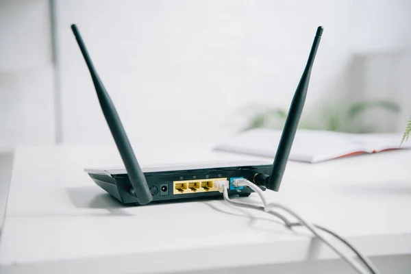 Router enchufado negro en la mesa de la oficina en sol - foto de stock