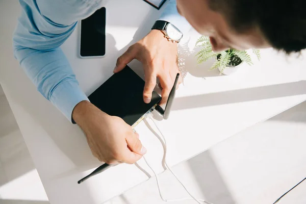 Selektiver Fokus des Geschäftsmannes, der Router auf den Bürotisch steckt — Stockfoto