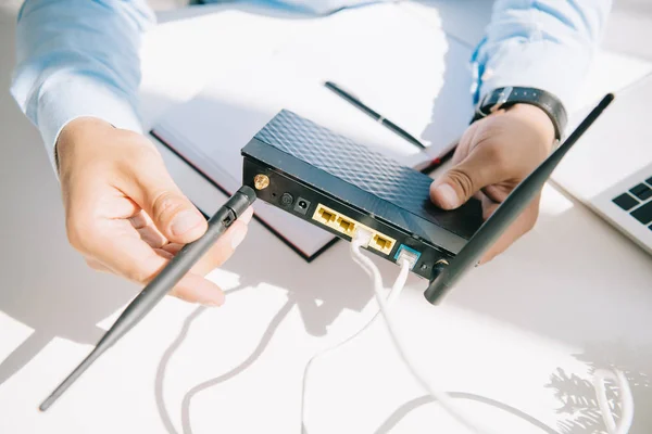 Ausgeschnittene Ansicht des Geschäftsmannes, der Antenne des Routers anpasst — Stockfoto