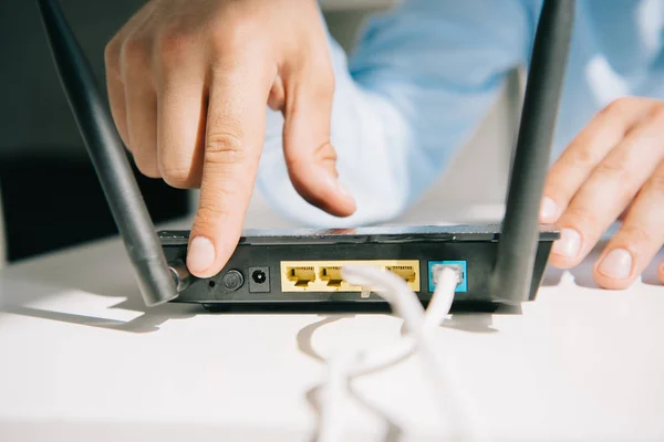 Ausgeschnittene Ansicht eines Geschäftsmannes, der Router einschaltet — Stockfoto