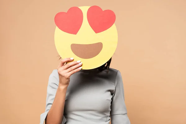 KYIV, UCRAINA - AGOSTO 1, 2019: donna in abito grigio volto oscuro con smiley con gli occhi del cuore su sfondo beige — Foto stock