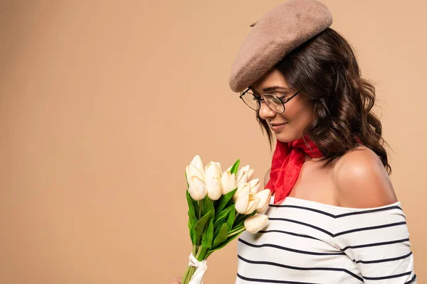Französin in Baskenmütze mit Blumenstrauß auf beigem Hintergrund — Stockfoto