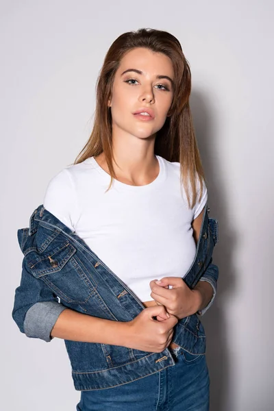 Beautiful woman in denim jacket looking at camera on white — Stock Photo