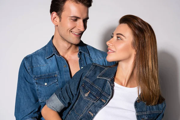 Pretty woman in denim jacket looking at man on white — Stock Photo