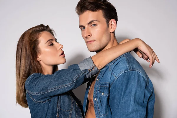 Jolie fille regardant bel homme en chemise en denim sur blanc — Photo de stock