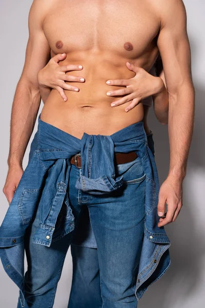 Cropped view of woman touching sexy muscular man on white — Stock Photo