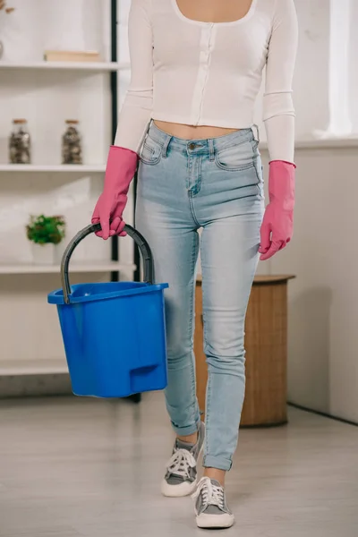 Cropped view of housewife in blue jeans holding bucket — Stock Photo