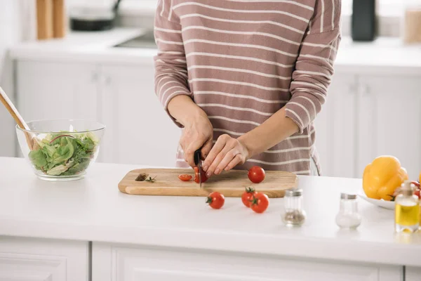 Vista ritagliata della donna che taglia pomodori allegri sul tagliere — Foto stock