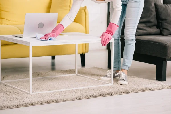 Vista cortada da mesa de limpeza da dona de casa com pano perto do laptop — Fotografia de Stock