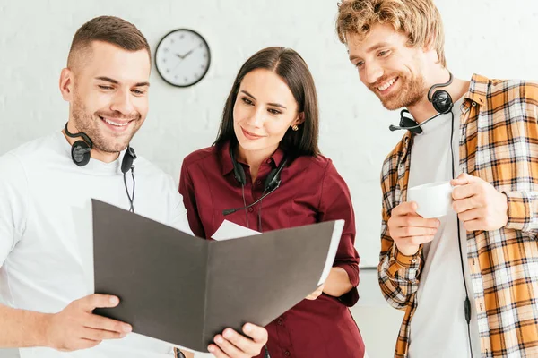 Happy brokers looking at folder and smiling in call center — Stock Photo