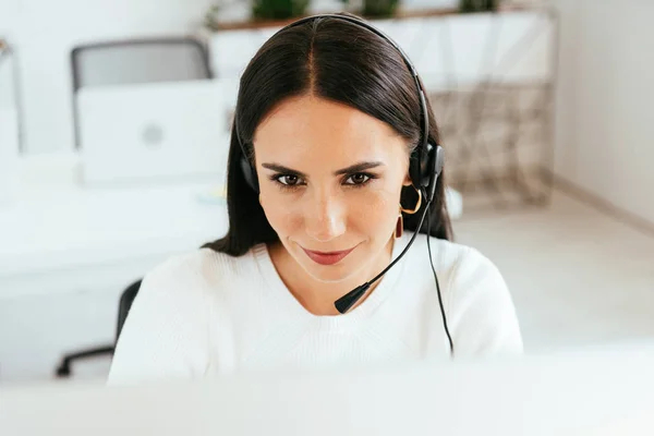 Foco seletivo do corretor atraente no fone de ouvido trabalhando no call center — Fotografia de Stock