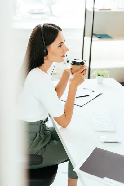 Selective focus of happy broker holding paper cup in office — Stock Photo