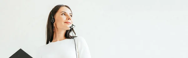 Panoramic shot of broker in headset holding clipboard — Stock Photo