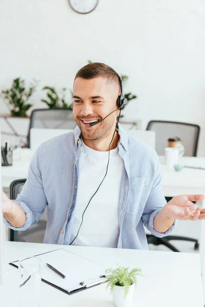 Feliz operador en la agencia de corredores mostrando gesto encogiéndose de hombros en la oficina - foto de stock