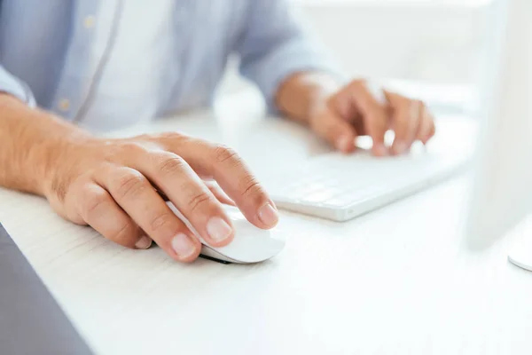 Vista ritagliata del broker utilizzando il mouse del computer vicino alla tastiera del computer — Foto stock