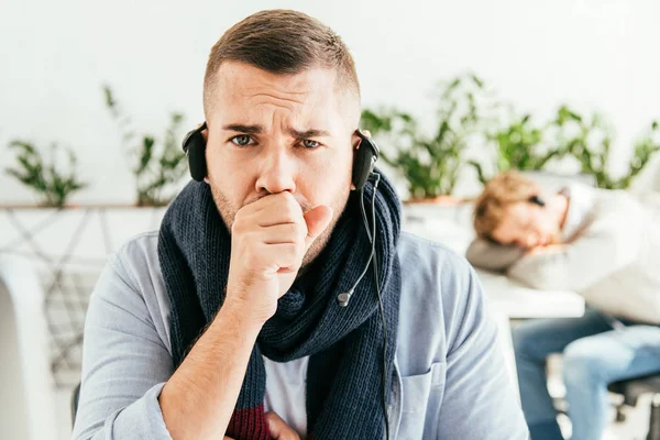 Selective focus of broker in scarf coughing near colleague in office — Stock Photo