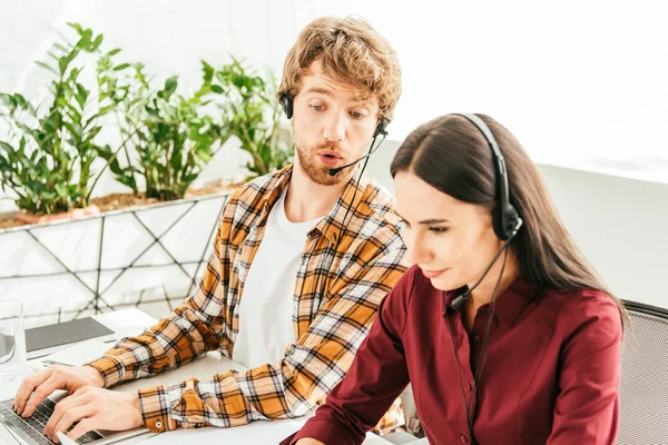 Selective focus of surprised breaded broker near attractive coworker in office — Stock Photo