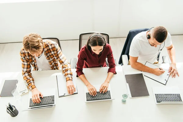 Vista superior de corretores em fones de ouvido que trabalham no call center — Fotografia de Stock