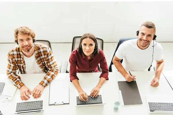 Overhead-Ansicht glücklicher Makler in Headsets, die im Call Center arbeiten — Stockfoto