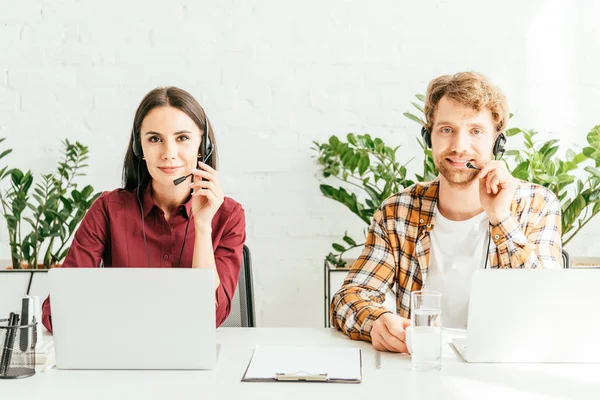 Mediatori felici toccando cuffie in ufficio — Foto stock