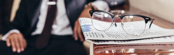 Panoramic shot of glasses and newspaper on table in private plane — Stock Photo