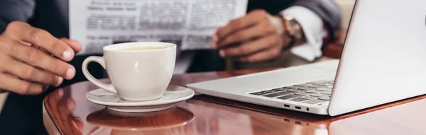 Panoramic shot of businessman taking cup in private plane — Stock Photo