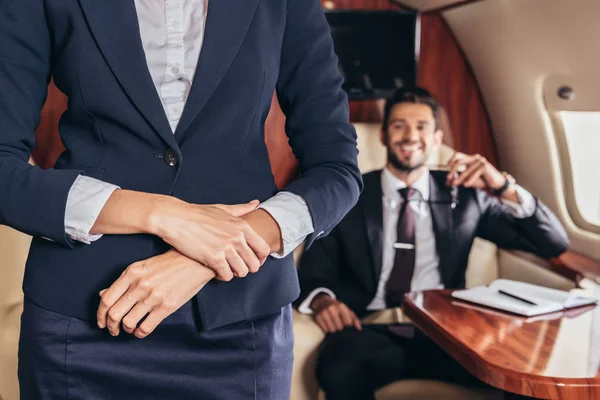 Vista cortada de comissário de bordo em uniforme em avião privado — Fotografia de Stock