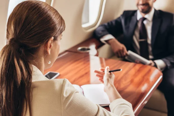 Enfoque selectivo del hombre de negocios y la mujer de negocios hablando en plano privado - foto de stock