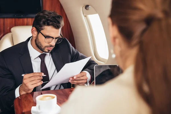 Orientation sélective de l'homme d'affaires tenant du papier dans un avion privé — Photo de stock