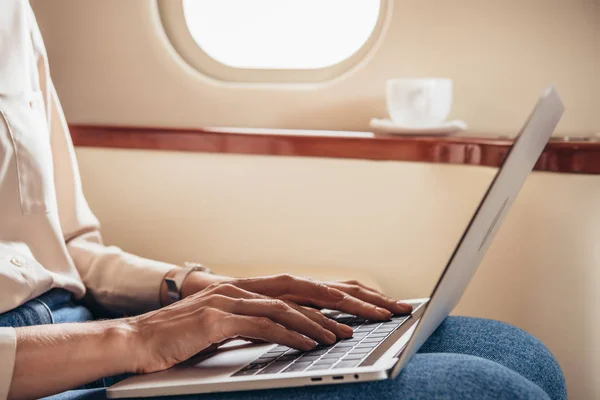 Ausgeschnittene Ansicht einer Frau mit Laptop im Privatflugzeug — Stockfoto