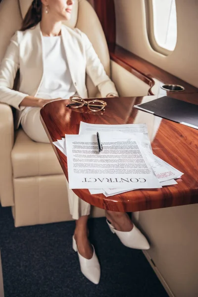Foyer sélectif de contrat et stylo sur table en bois dans l'avion privé — Photo de stock