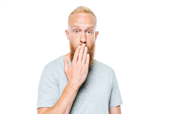Здивований чоловік у сірій футболці, що закриває рот, ізольований на білому — стокове фото