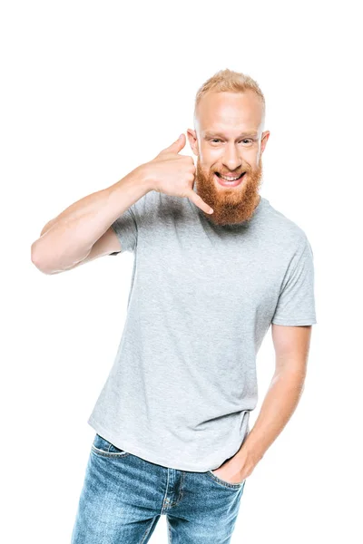 Bell'uomo sorridente in t-shirt grigia che mostra chiamami gesto, isolato su bianco — Foto stock