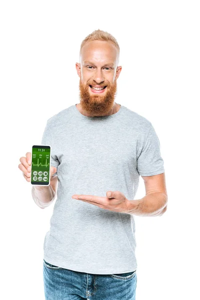 Hombre alegre mostrando teléfono inteligente con aplicación de salud, aislado en blanco - foto de stock