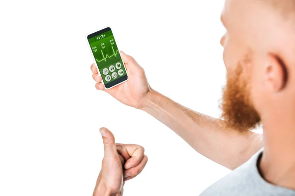 Hombre mostrando el pulgar hacia arriba y mirando el teléfono inteligente con aplicación de salud, aislado en blanco - foto de stock