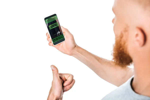 Hombre mostrando el pulgar hacia arriba y mirando el teléfono inteligente con aplicación de reserva, aislado en blanco - foto de stock