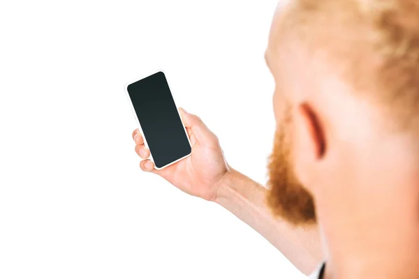 Обрізаний вид чоловіка, який дивиться на смартфон з порожнім екраном, ізольований на білому — стокове фото