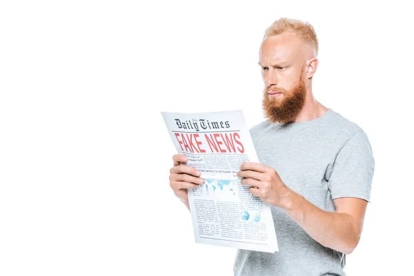 Schöner ernsthafter Mann liest Zeitung mit Fake News, isoliert auf weiß — Stockfoto